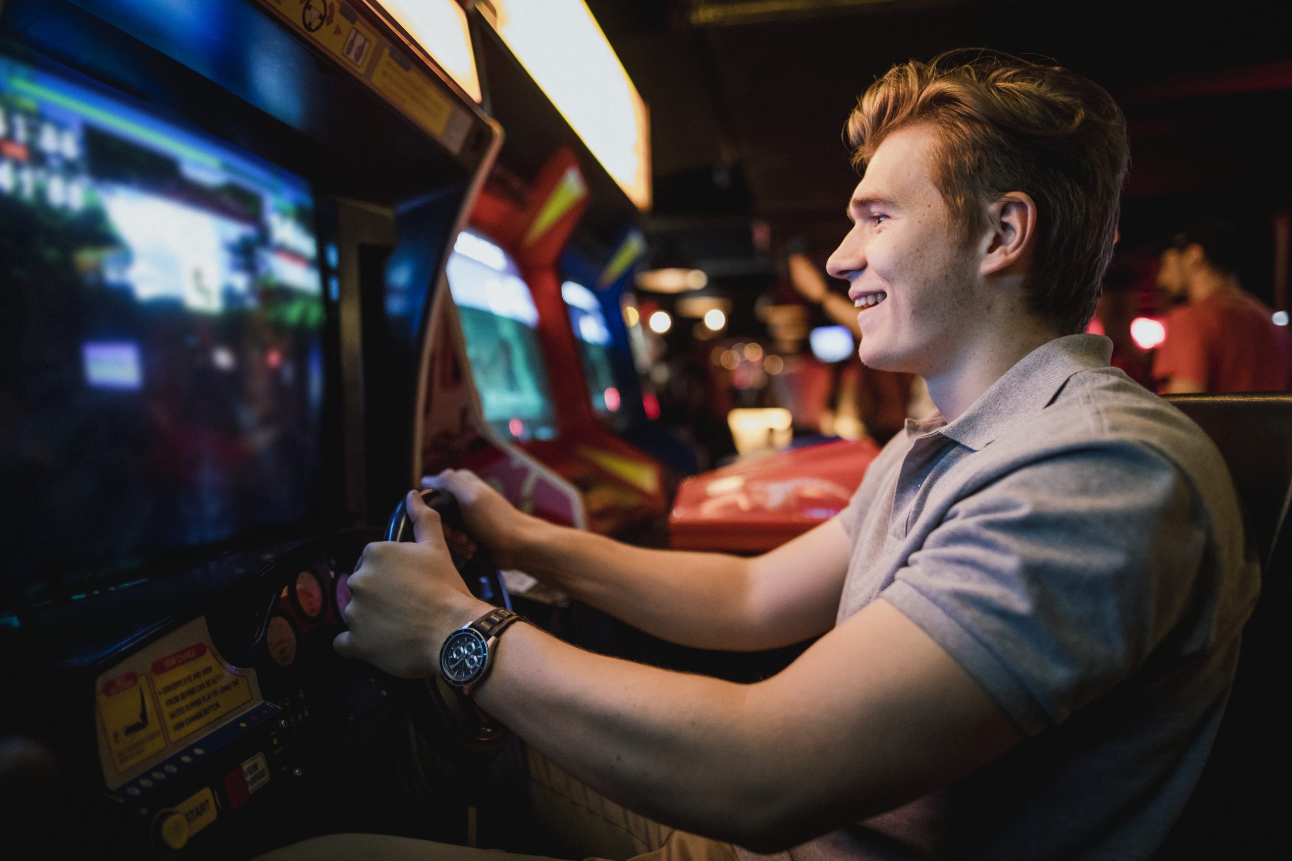 Teenager playing car racing arcade
