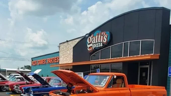 Cars are parked near Mr. Gatti Pizza franchise with the pizza franchise business and franchise pizza.
