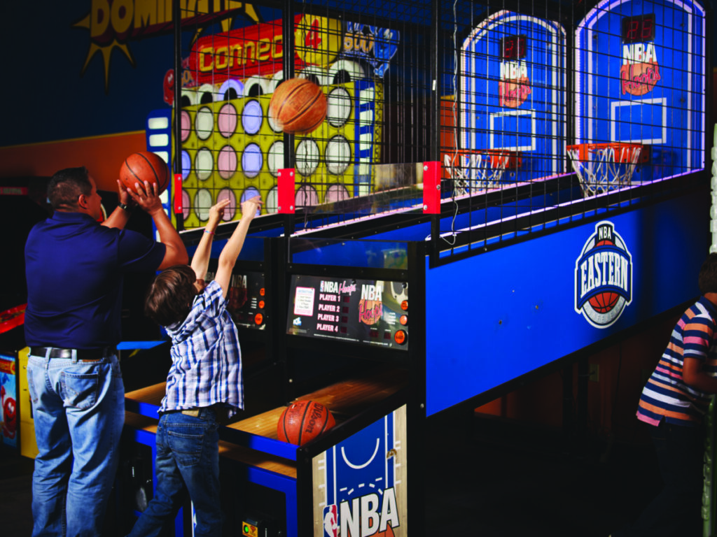 Dad and son Enjoy playing in Mr. Gatti's Pizza Franchise arcade indoor basketball with the arcade games and ordering system.